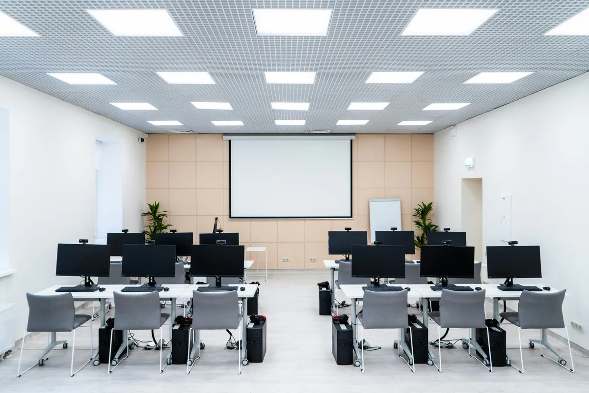 Ein heller Klassenraum mit Computerarbeitsplätzen.